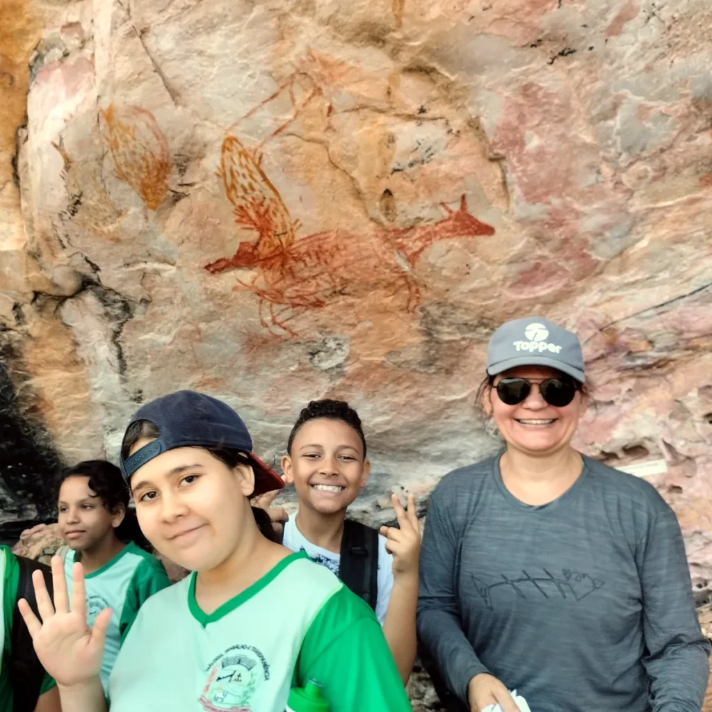 Foto de alunos da rede pública de ensino durante passeio pelo sítio arqueológico Lapa Vau da Lagoa em Minas Gerais.