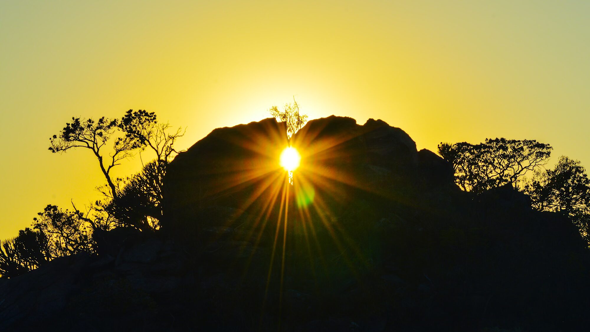 Foto do Sol se pondo durante solstício no sítio arqueológico Pedra do Sol em Minas Gerais.